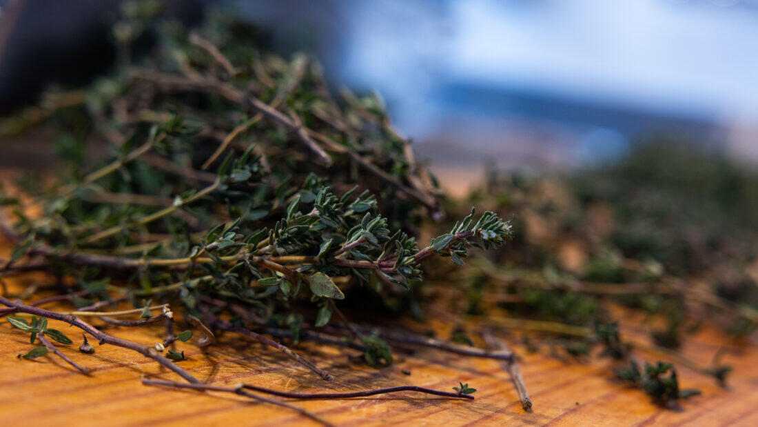 Fresh thyme on a wooden board beside the fire
