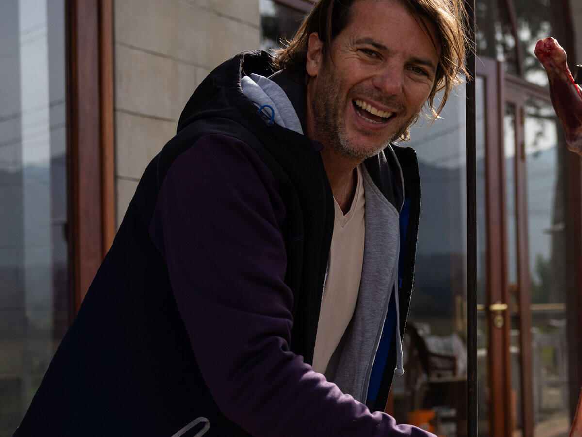 Chef Juan Andres Vais laughing at the fire